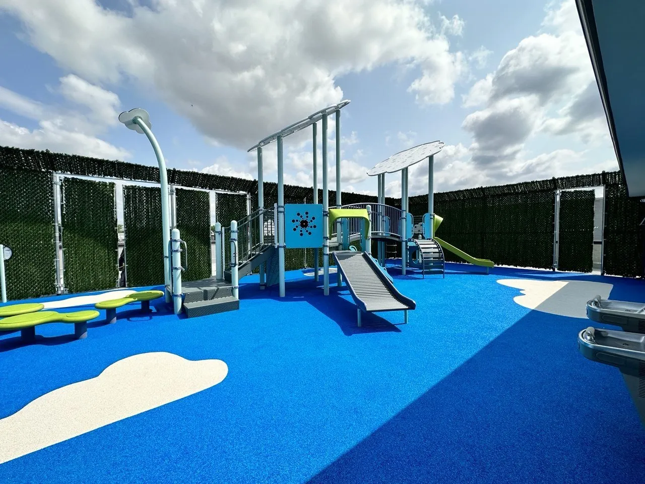 The rooftop playground with slides and cloud-shaped shades