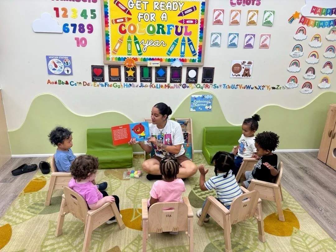 A teacher reading a picture book to toddlers at circle time