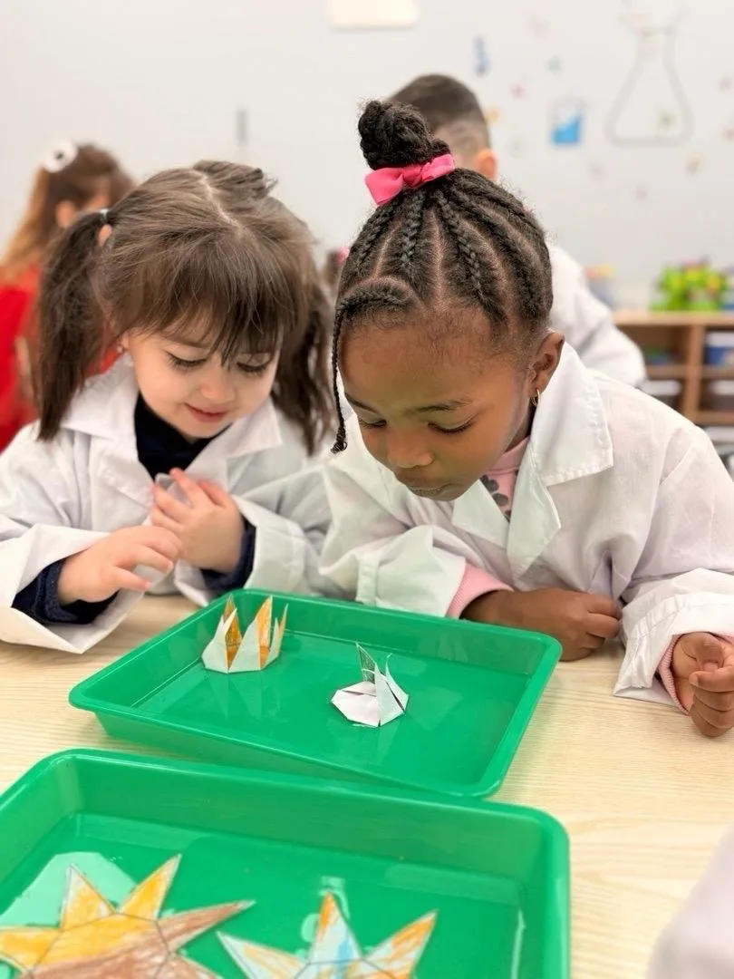 Two children in lab coats doing a science experiment