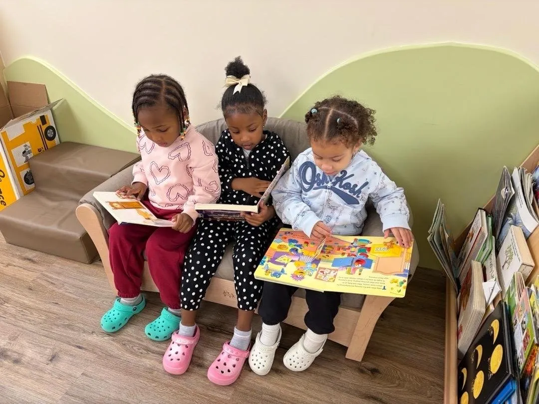 Three children reading picture books together